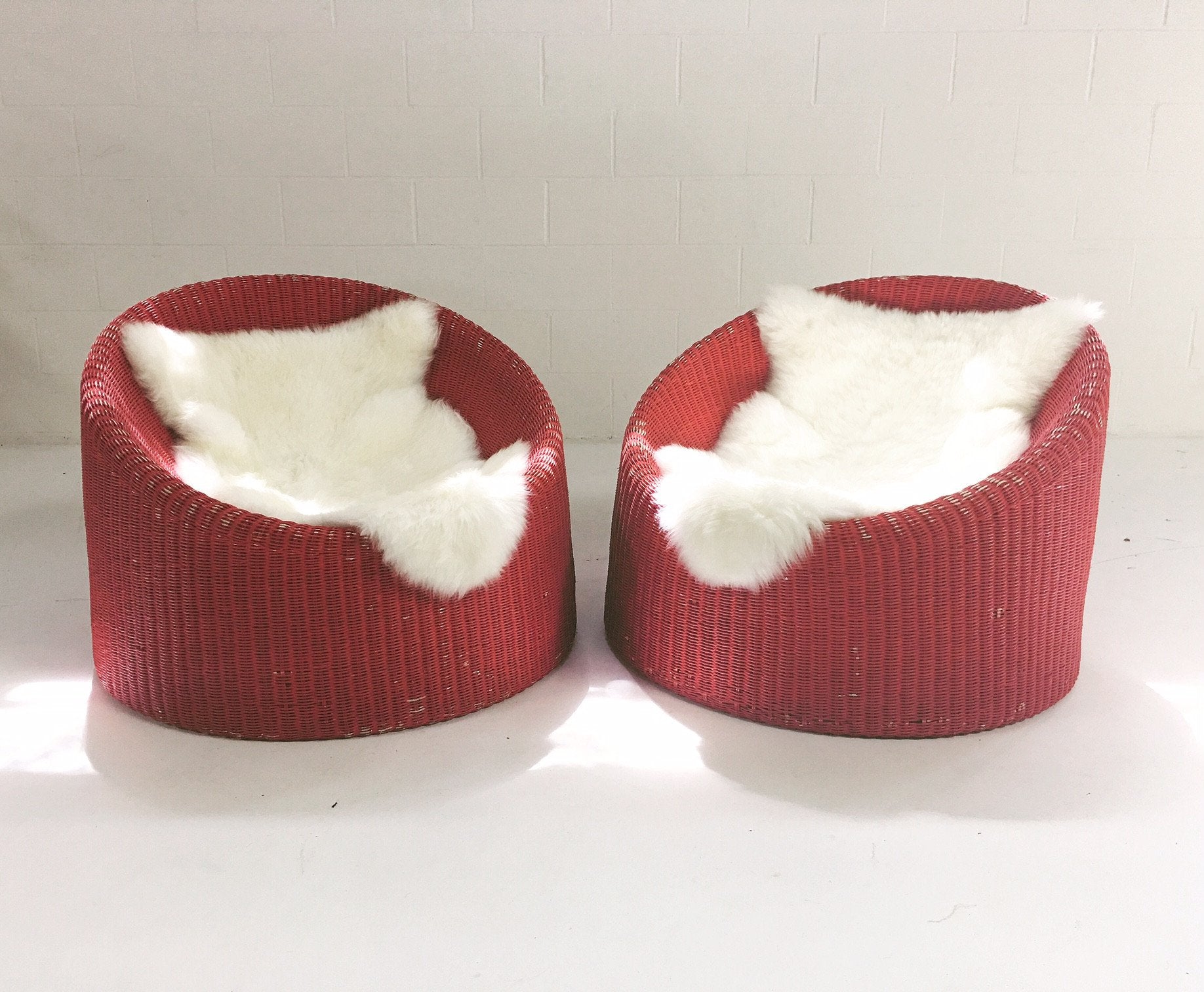 PAIR of EERO AARNIO FOR STENDIG WOVEN RATTAN LOUNGE CHAIRS WITH SHEEPSKIN THROWS