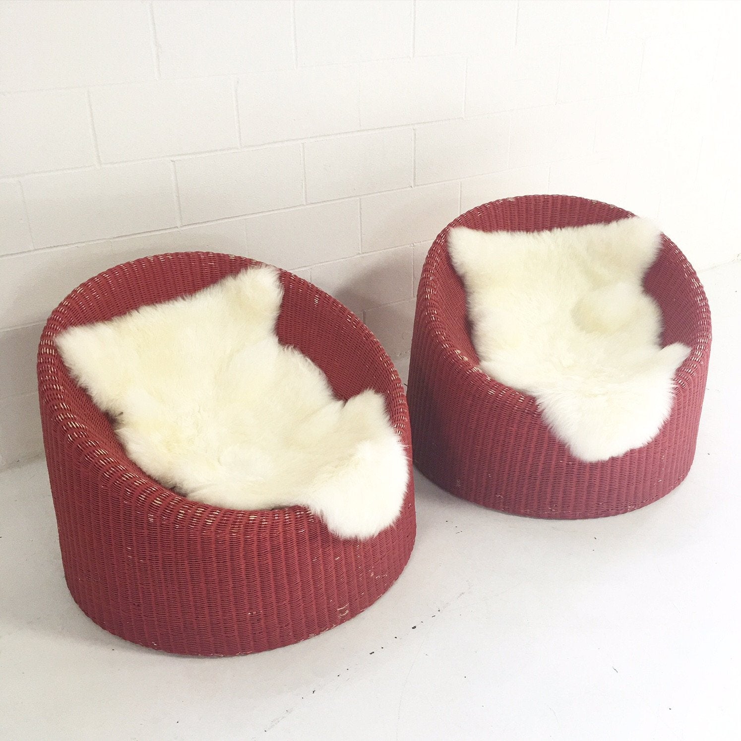 PAIR of EERO AARNIO FOR STENDIG WOVEN RATTAN LOUNGE CHAIRS WITH SHEEPSKIN THROWS