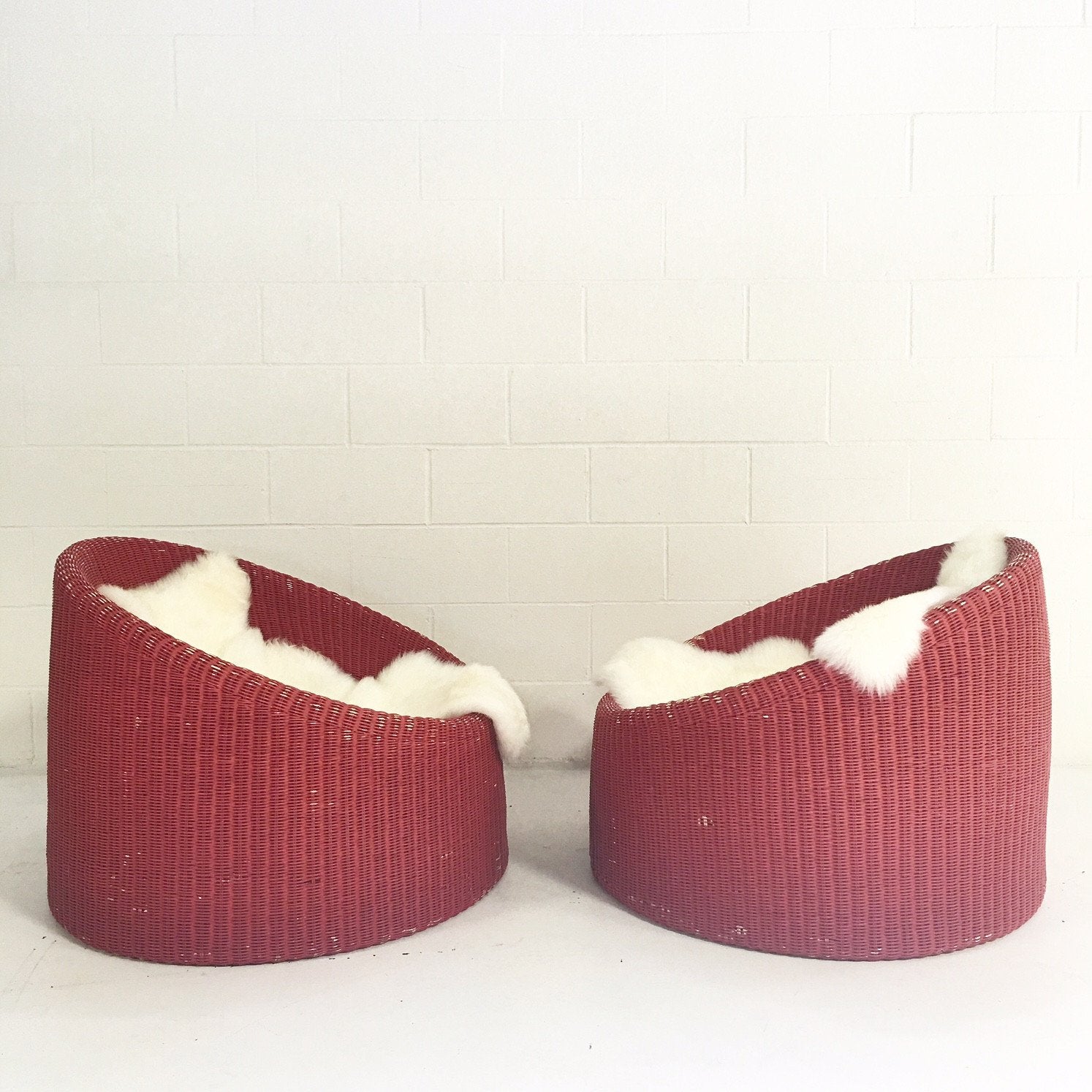 PAIR of EERO AARNIO FOR STENDIG WOVEN RATTAN LOUNGE CHAIRS WITH SHEEPSKIN THROWS