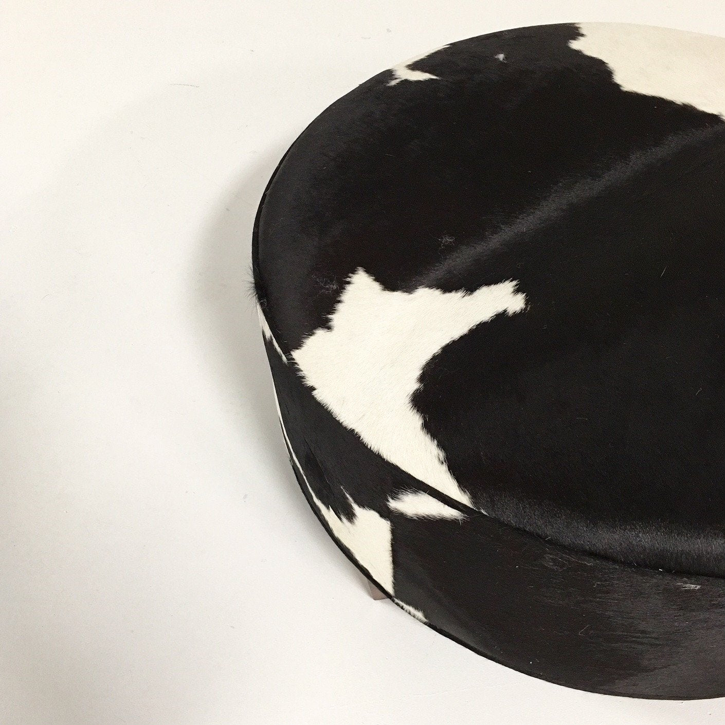 ROUND BLACK & WHITE COWHIDE OTTOMAN
